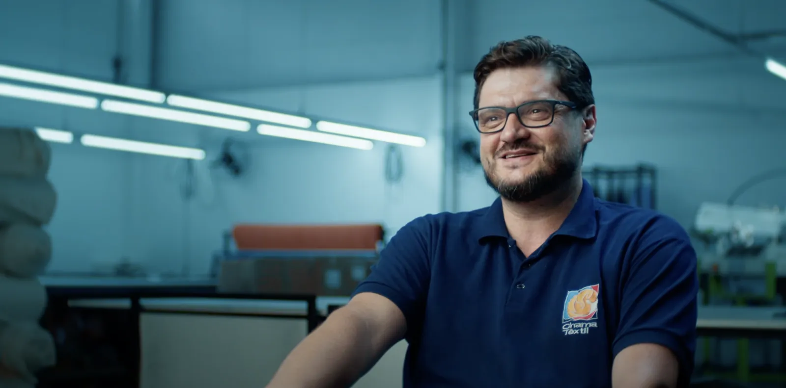 Empresário sorrindo durante entrevista gravada no chão de fábrica